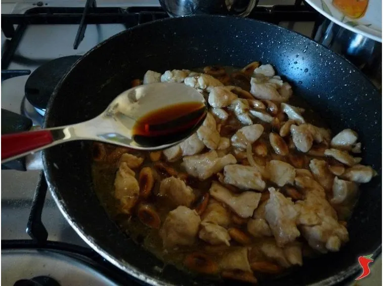 dopo avere saltato il pollo aggiungo la salsa di soia e le mandorle